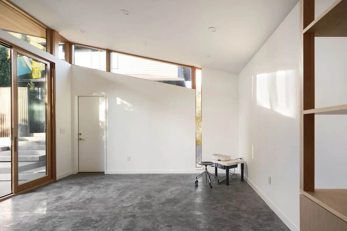 Interior of Studio: Portland by Webster Wilson Architect showing concrete floors and wood window frames.