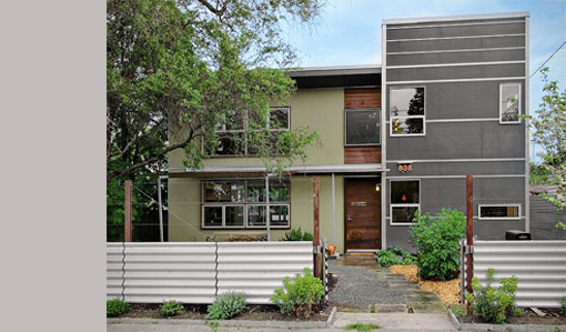 The Donovan Street House features a mix of siding colors with horizontal window bands and a metal fence at the front.