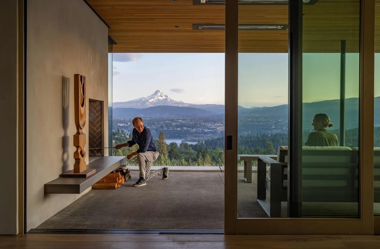 Modern fireplace interior with expansive glass wall framing mountain scenery at Bald Mountain Residence by Scott | Edwards Architecture.