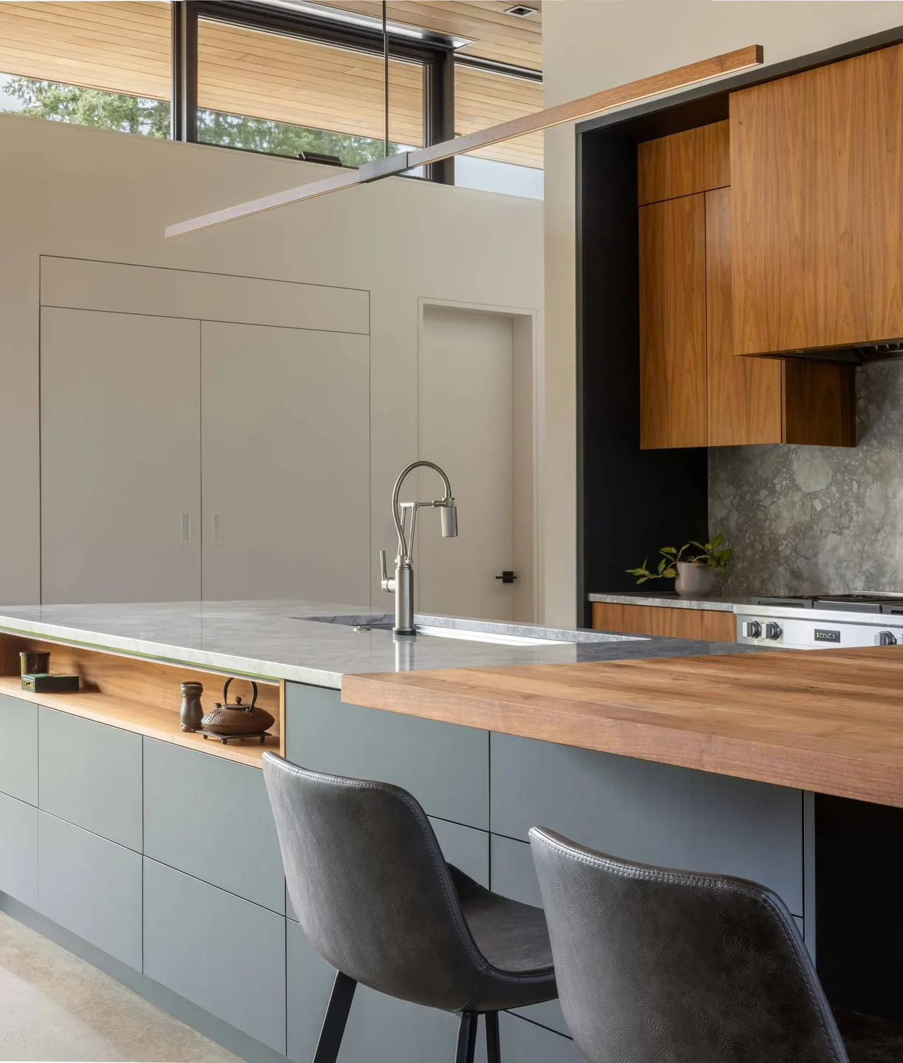 The kitchen features a marble countertop island with a built-in wood breakfast bar and wood upper cabinetry.