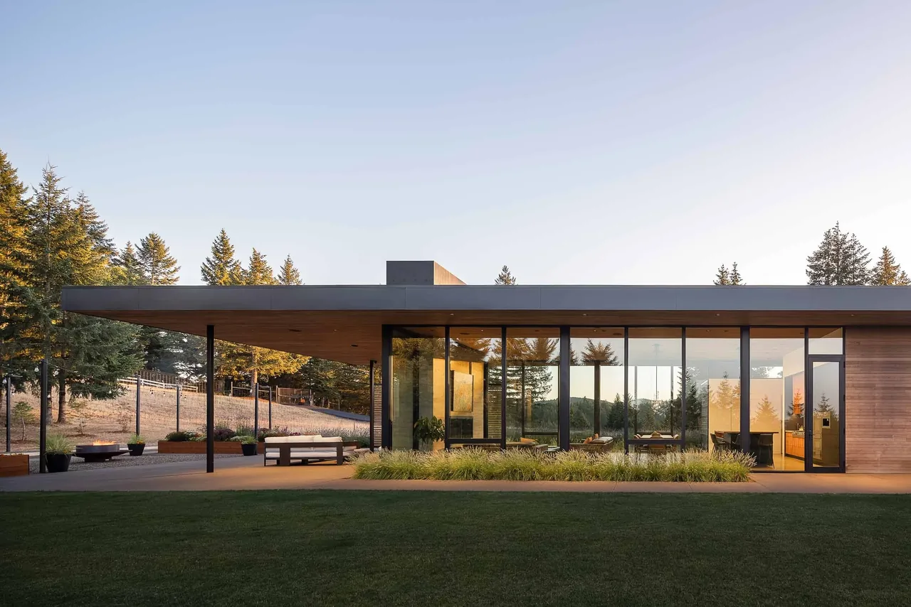 The single-story 'Evening Sky' house shows modern design with a flat roof and expansive glazing by Scott | Edwards Architecture.