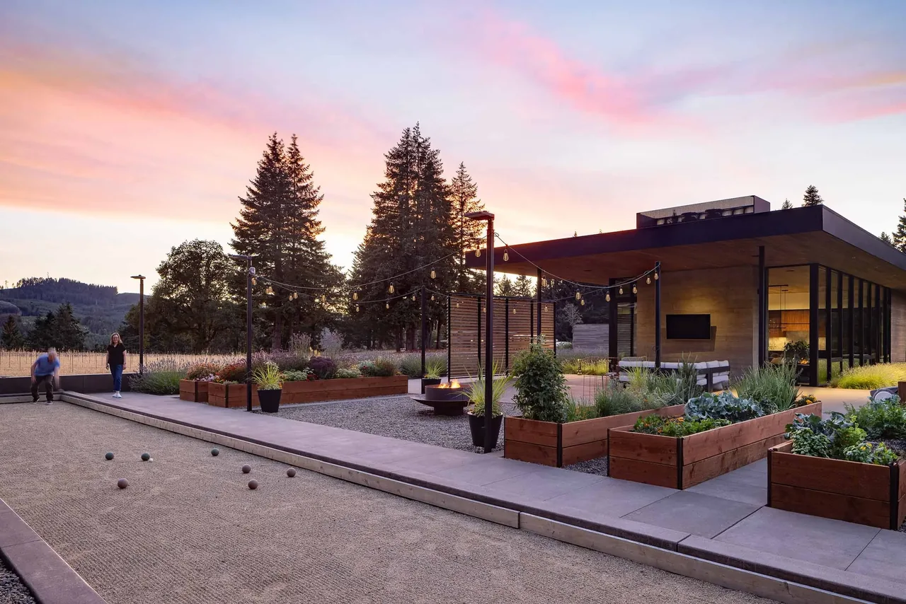 The Evening Sky project features a modern design with a covered patio, black window frames, and landscaped planting beds.