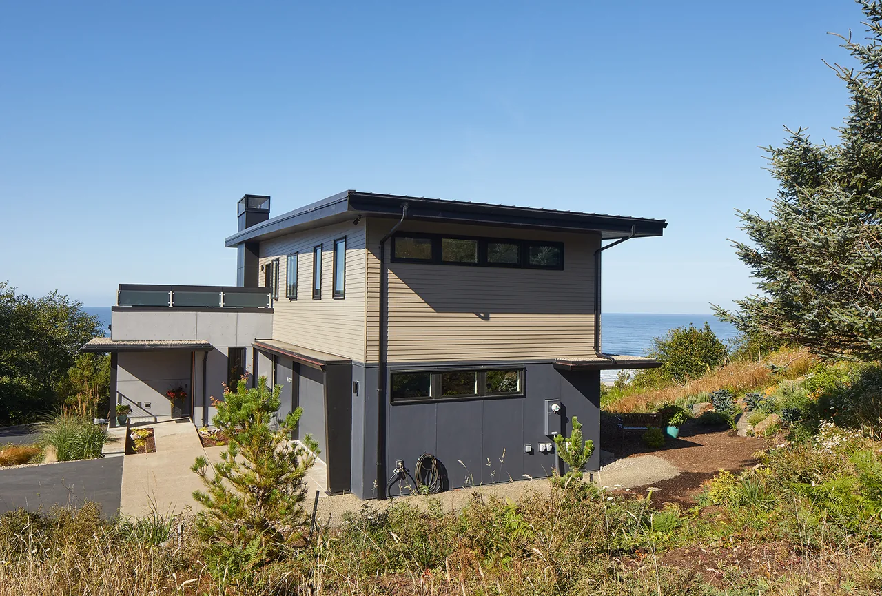 Sahhali Shores Shelter features a modern multi-story design with contrasting beige and black exterior surfaces and ocean views.