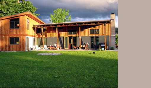 Herb Farm House features wood siding and a covered outdoor patio with seating around a firepit.