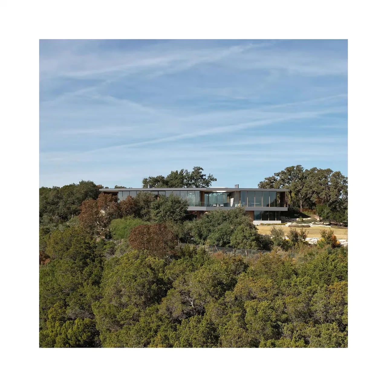 City Park Residence by Alterstudio showcases a modern home integrated into a wooded hillside landscape.
