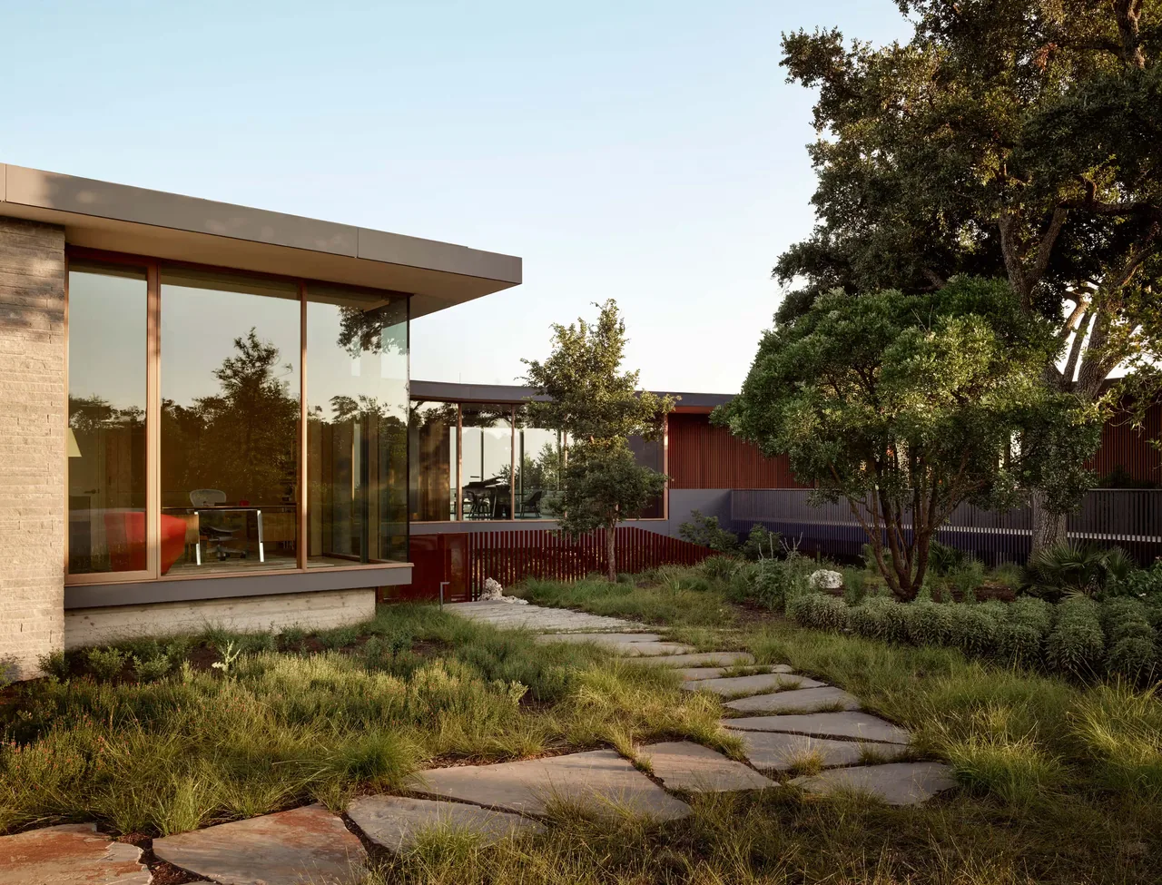 City Park Residence features a modern design with floor-to-ceiling glazing and stone pathway landscaping.