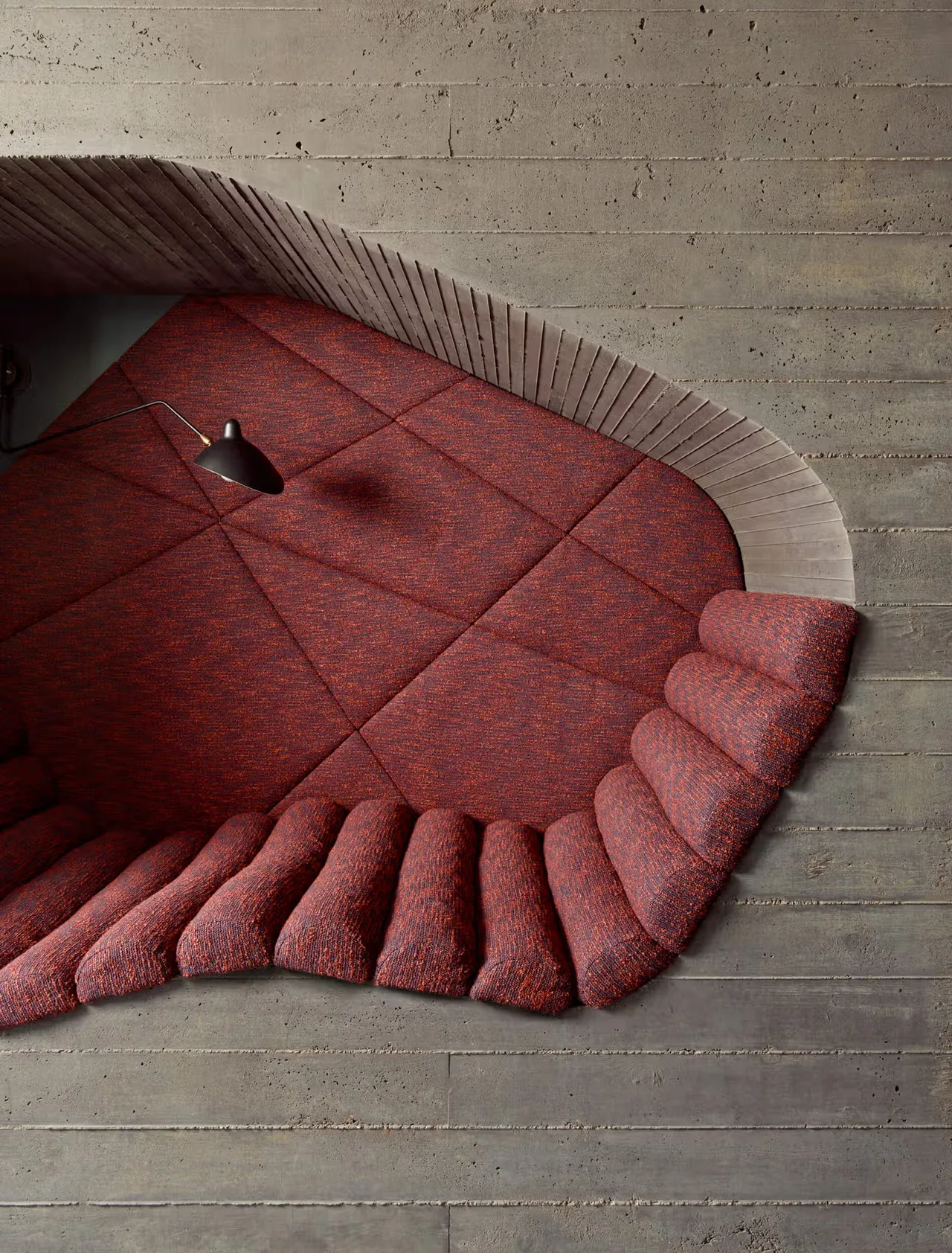 Custom red fabric bench integrated into a concrete niche with angled detailing at Barton Hills Residence by Alterstudio.