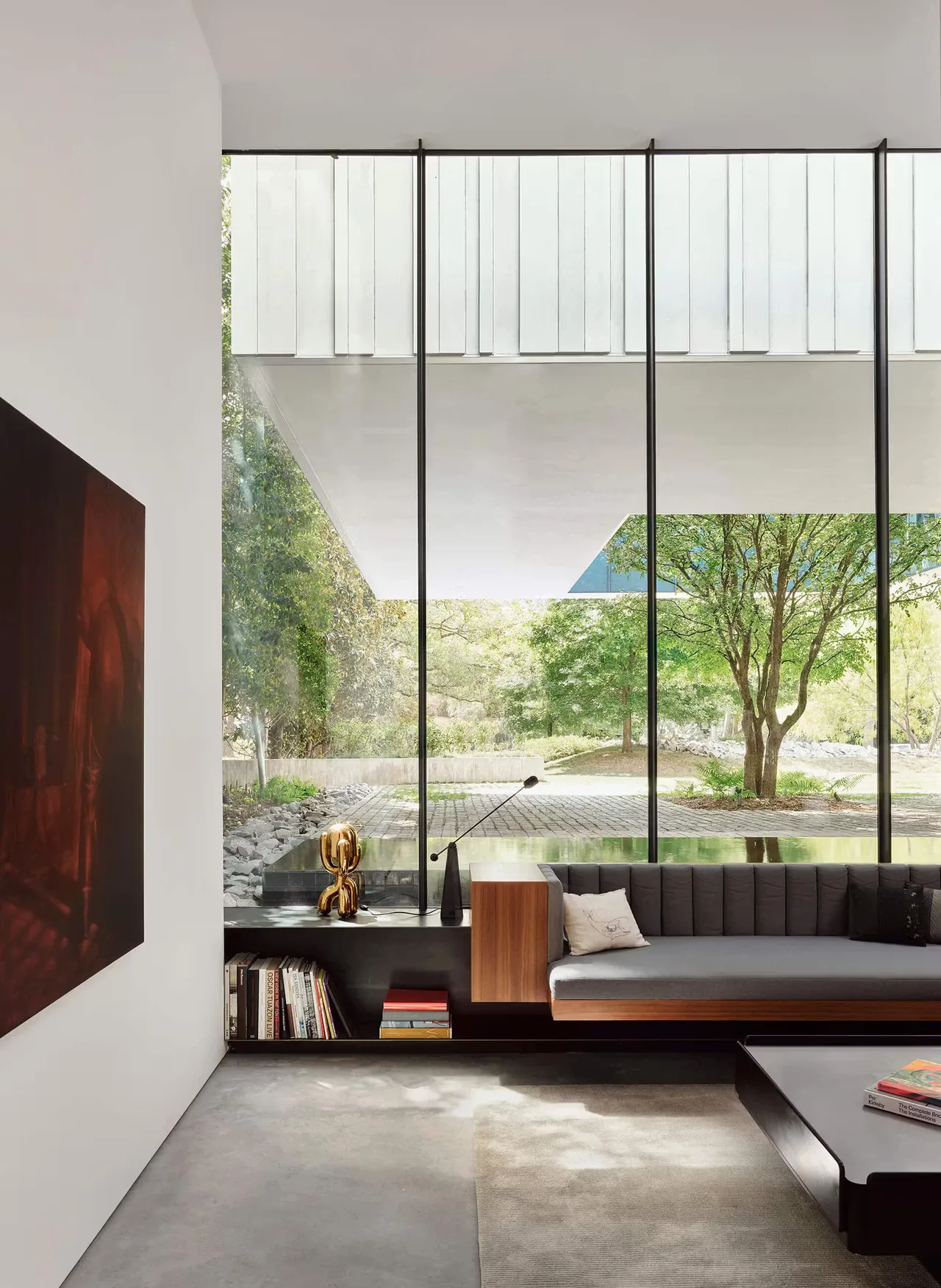 Living room in the Highland Park Residence features large floor-to-ceiling glass windows with vertical black frames.