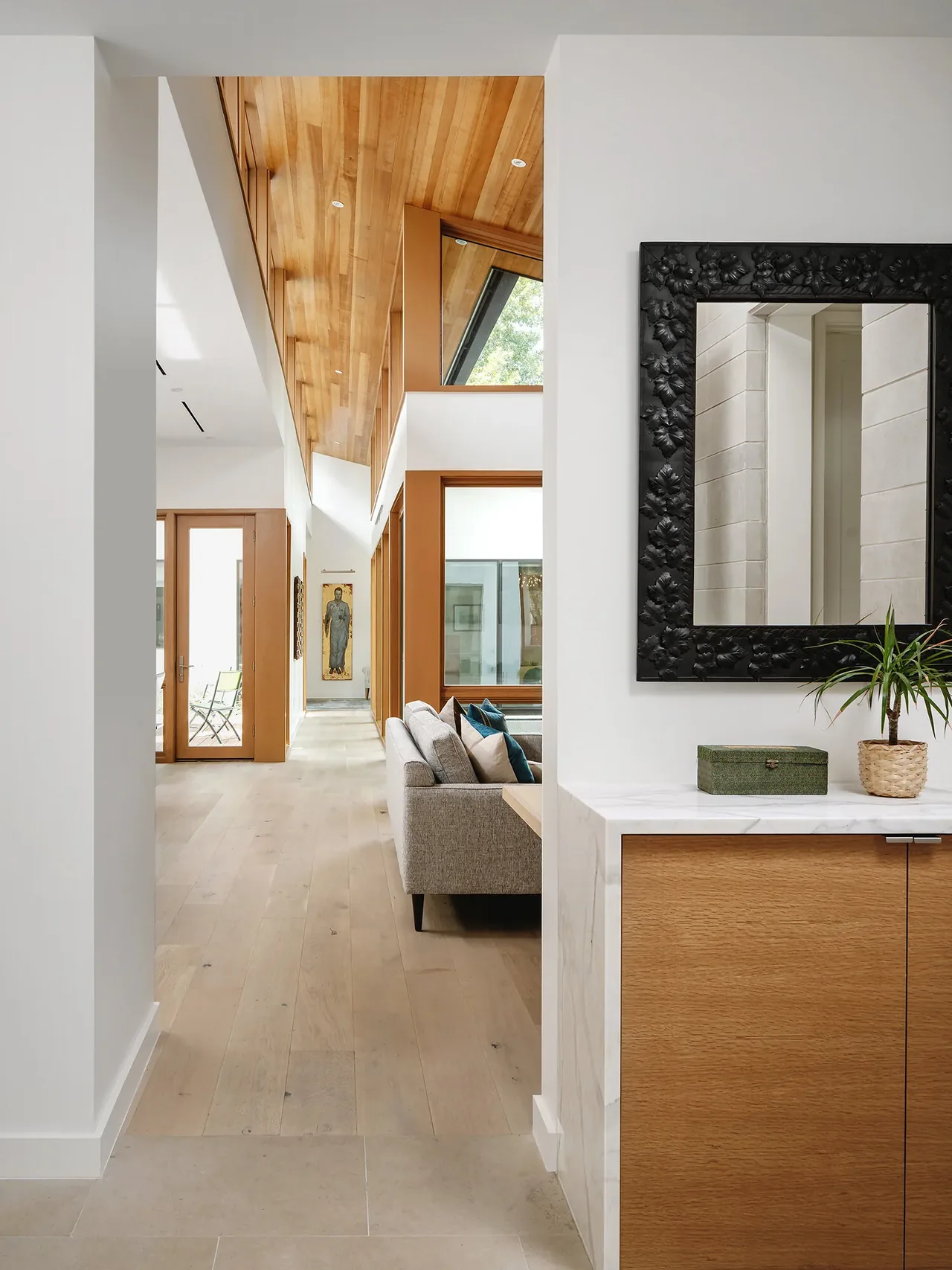 Hallway in the Ramsey residence featuring wood-paneled ceiling and light wood flooring by Clark | Richardson Architects.