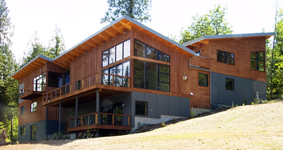 Hillside House by Silo Architecture + Design features wood siding, large window groups, and a multi-level roof design.