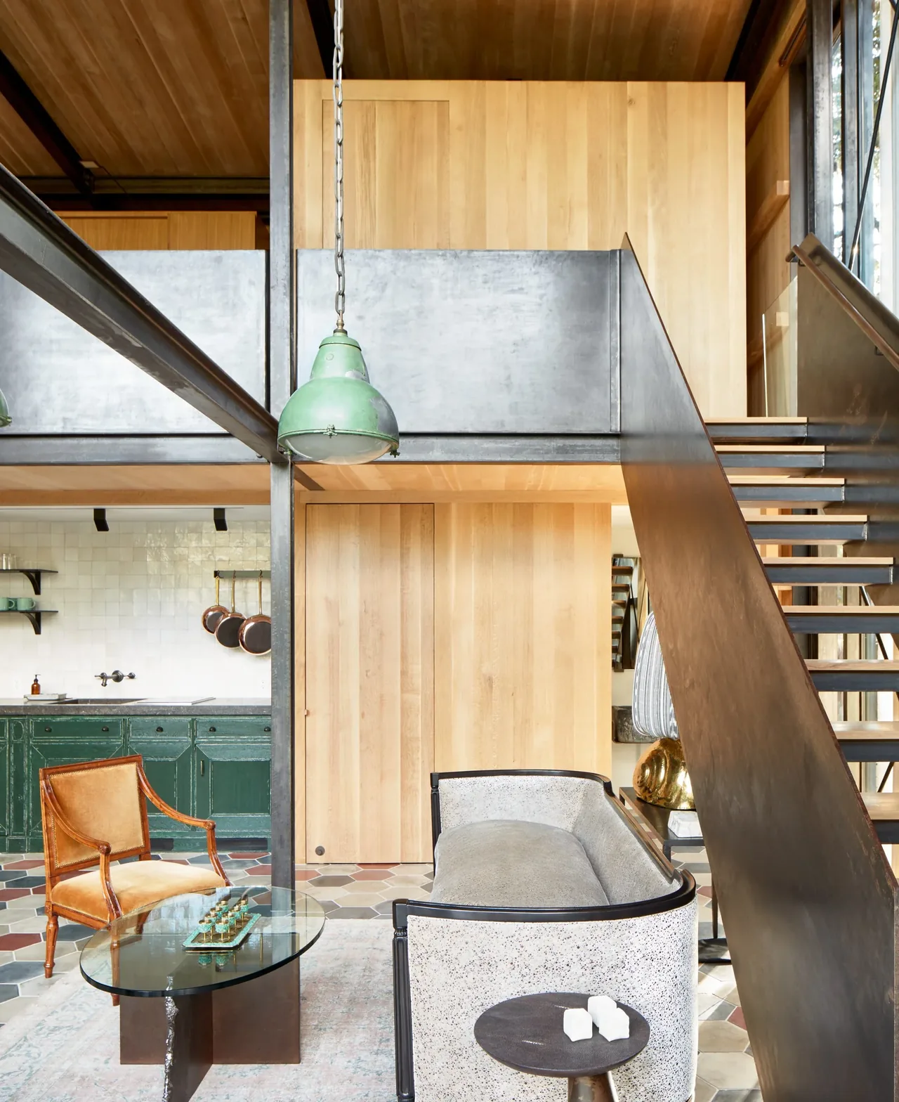 Living room seating area with industrial pendant lighting and a mix of leather and upholstered chairs.