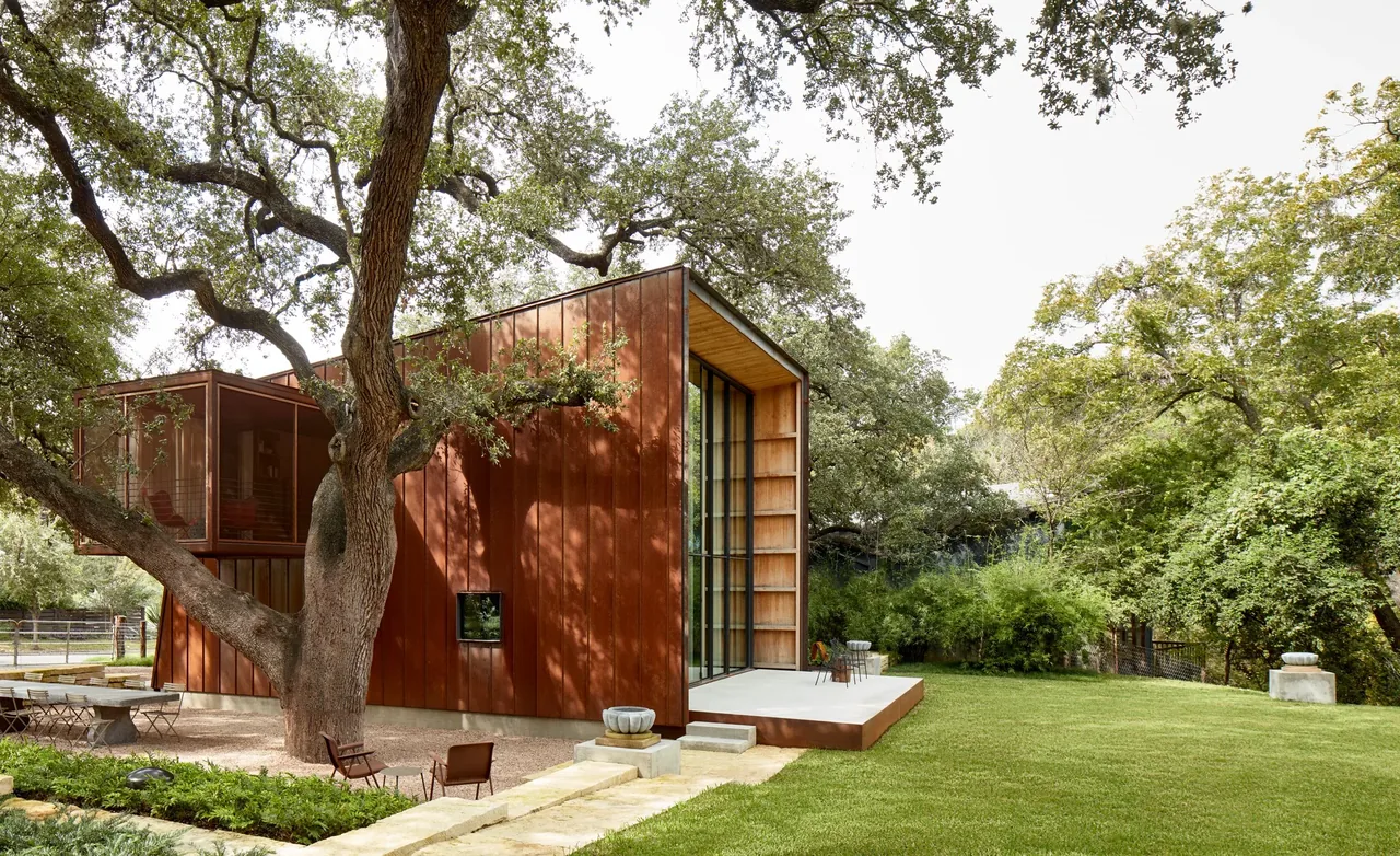 The Jewell Box features corten steel siding and floor-to-ceiling glazing, blending with its wooded surroundings in Austin.