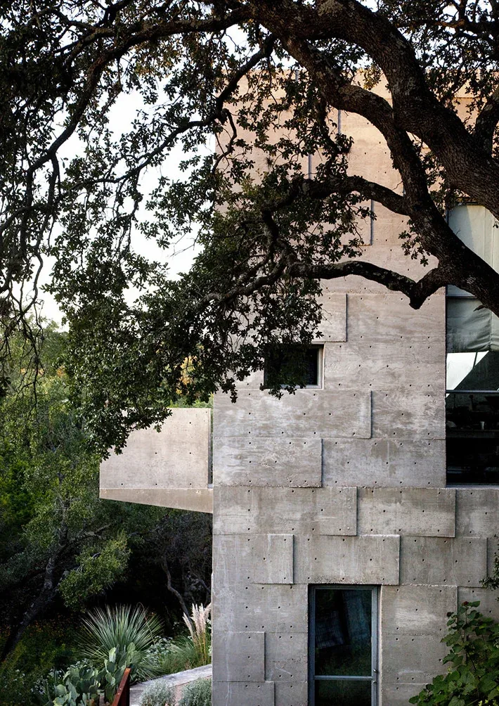 Concrete Studio Gallery features textured concrete walls with small rectangular windows and a cantilevered balcony.