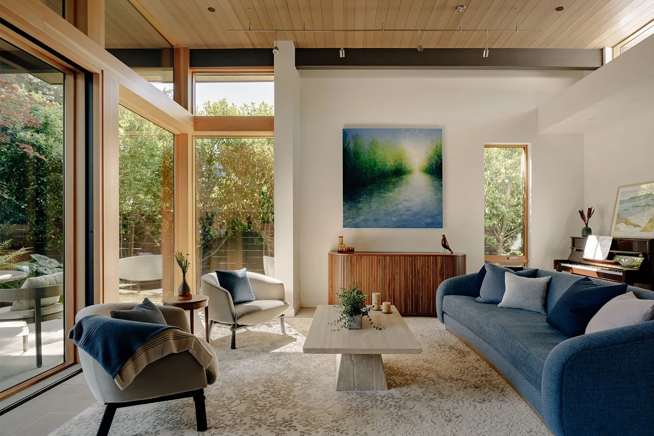 Living room interior with floor-to-ceiling glazing and natural wood window frames in the Ross Road project.