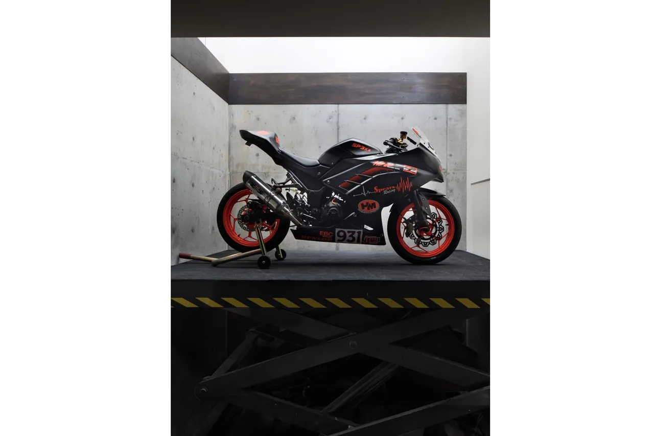 Sport motorcycle displayed on a platform inside a room with concrete and wood walls at moto house.