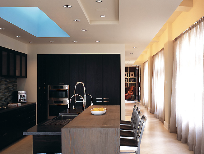 The Porter Residence kitchen features a central island with built-in sink and skylight enhancing natural light.
