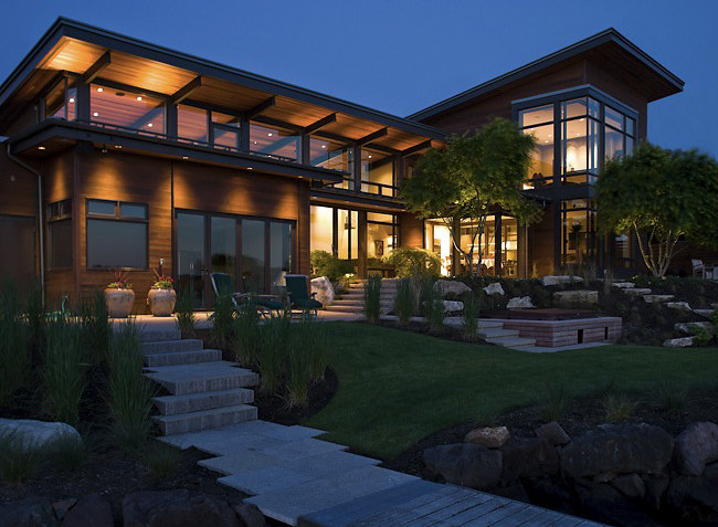 Night exterior of the Porter Residence featuring extensive glazing and wood siding with landscaped steps.