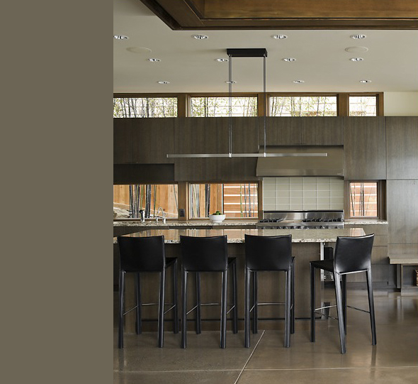 Porter Residence kitchen features a large island with black stools, wood cabinets, and built-in oven by skB Architects in Seattle.