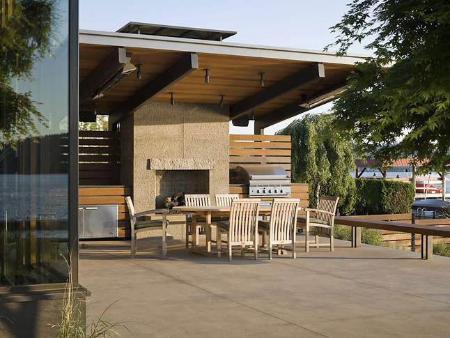 Covered patio with outdoor dining set, fireplace, and built-in grill at Porter Residence.