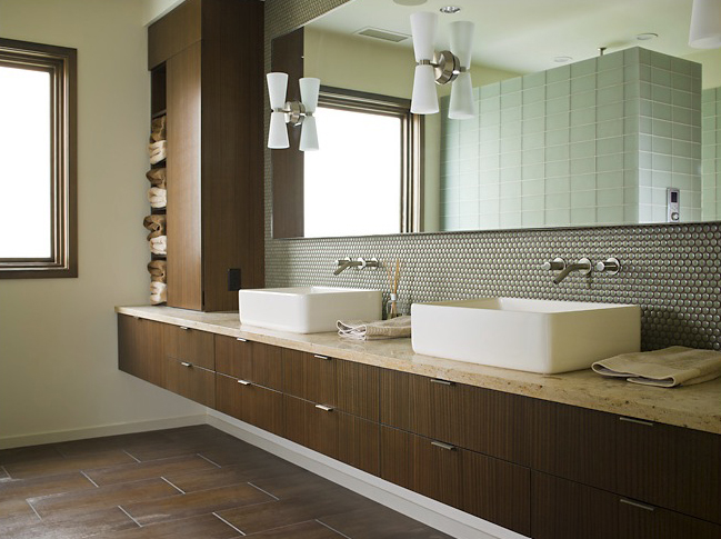The Porter Residence features a contemporary bathroom with dual vessel sinks, a textured backsplash, and wall-mounted faucets.