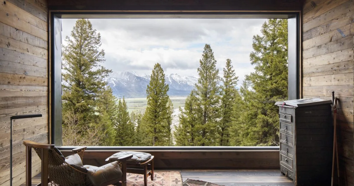 Camp Teton interior with large picture window overlooking trees and mountains.