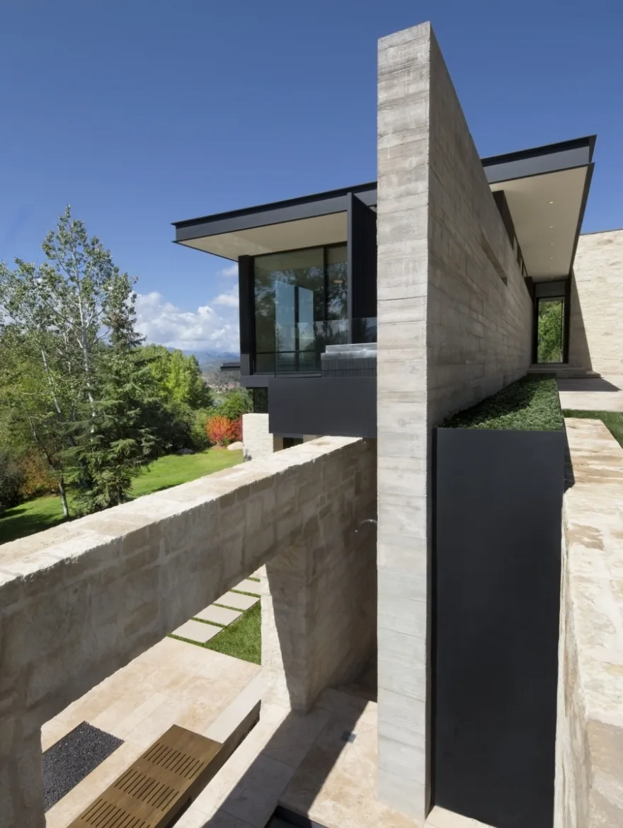 Aspen Residence features a stone exterior with cantilevered overhangs and black metal accents.