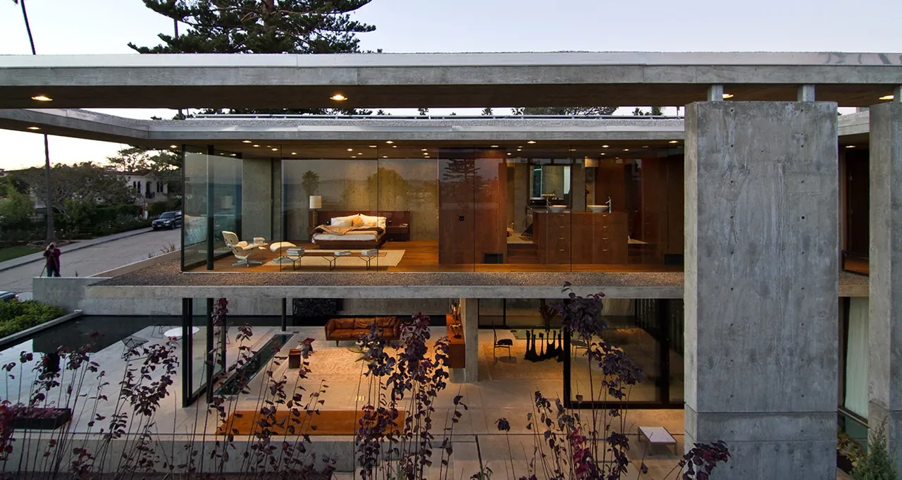 The Cresta features floor-to-ceiling glazing and concrete construction in this view showing living and bedroom spaces.