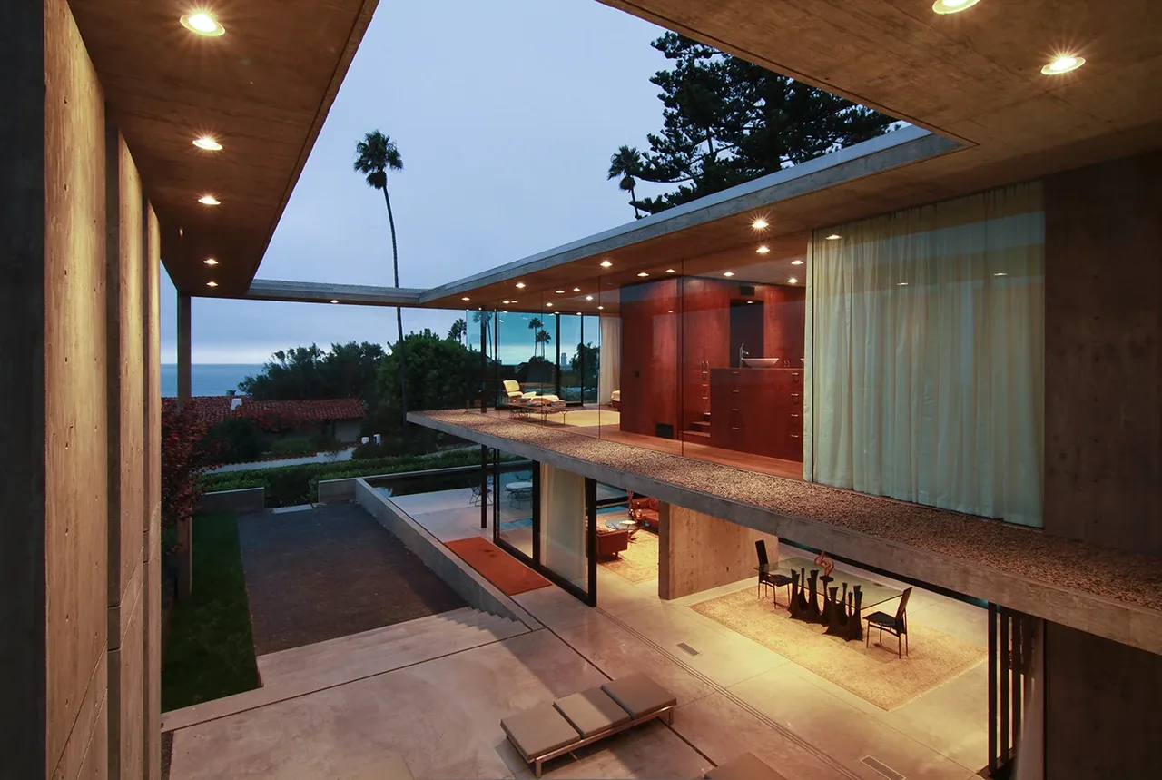The Cresta by Jonathan Segal features exposed concrete surfaces and glass enclosures with recessed ceiling lights.