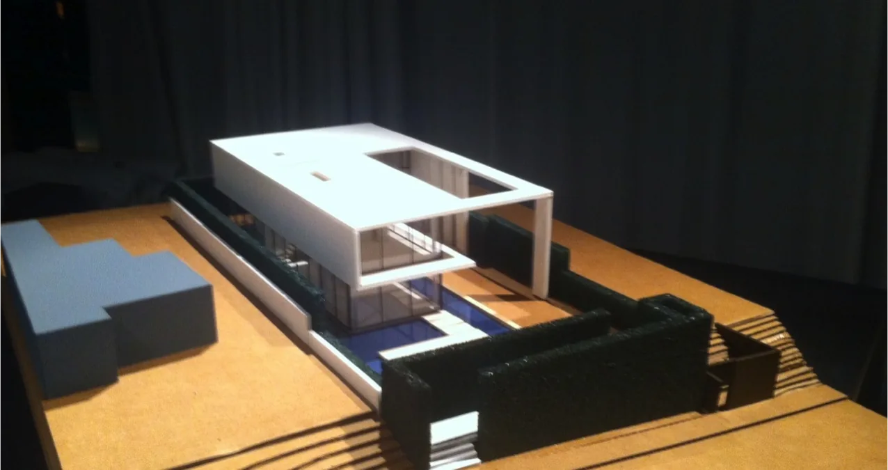 Model of The Cresta project showing a boxy form with a rectangular courtyard and glass balcony railing.