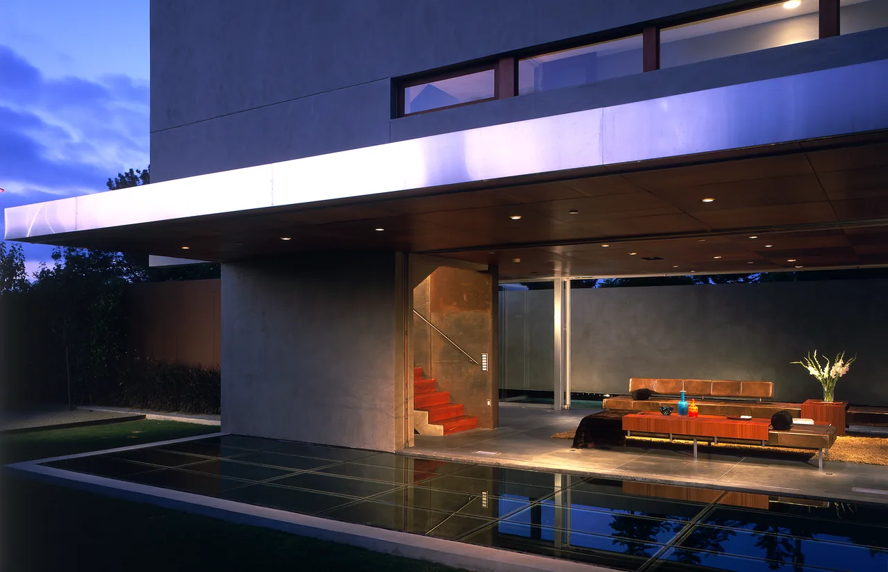 Modern living space with floor-to-ceiling windows overlooking a reflecting pool at The Prospect by Jonathan Segal.