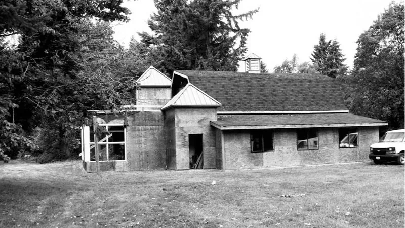 Exterior rear view of the Vashon project featuring concrete walls and a multi-pitched roof design.