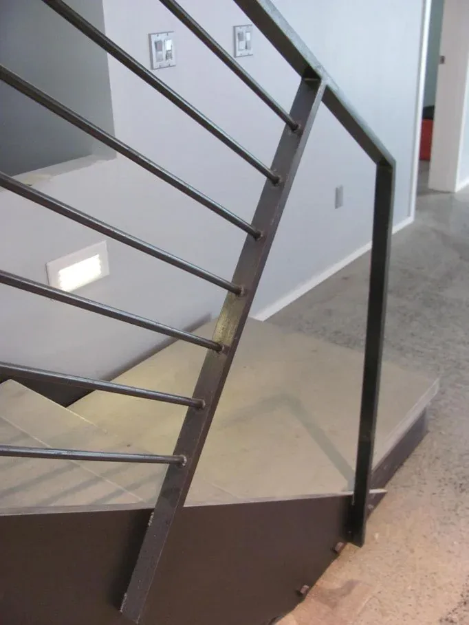 Black metal staircase railing with horizontal bars complements the modern interior of this home.