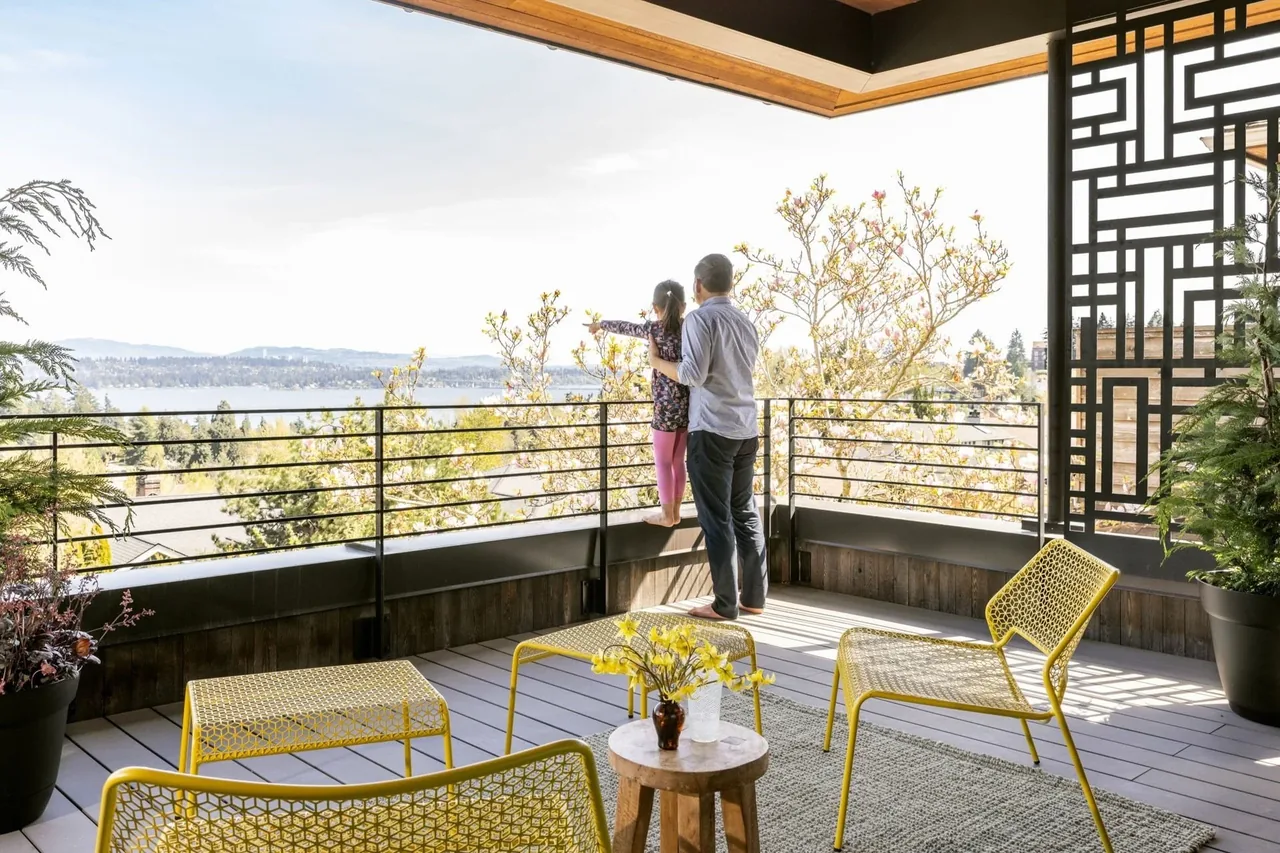 Covered outdoor patio area with yellow metal furniture and scenic water view in Seattle project 2.0.