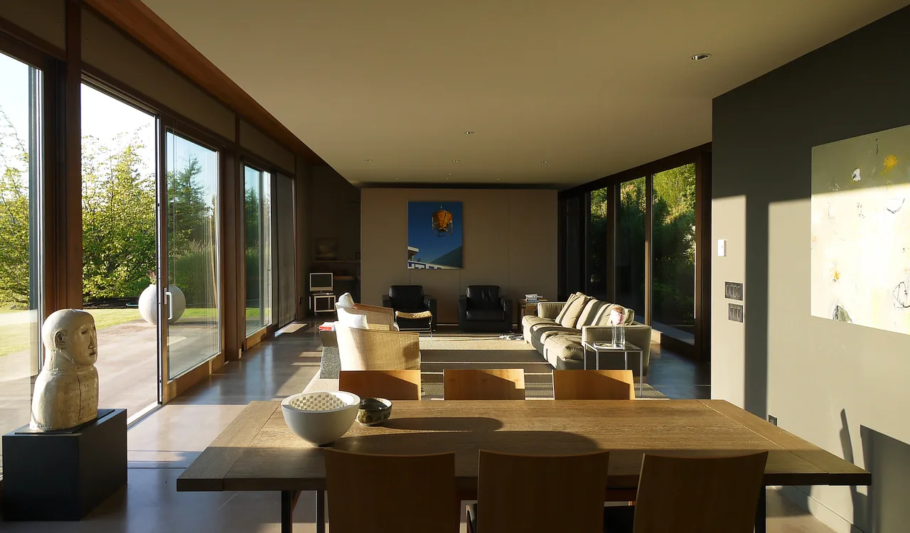 The House, Wall + Garden project features a living area with floor-to-ceiling glass doors and neutral furniture overlooking the garden.