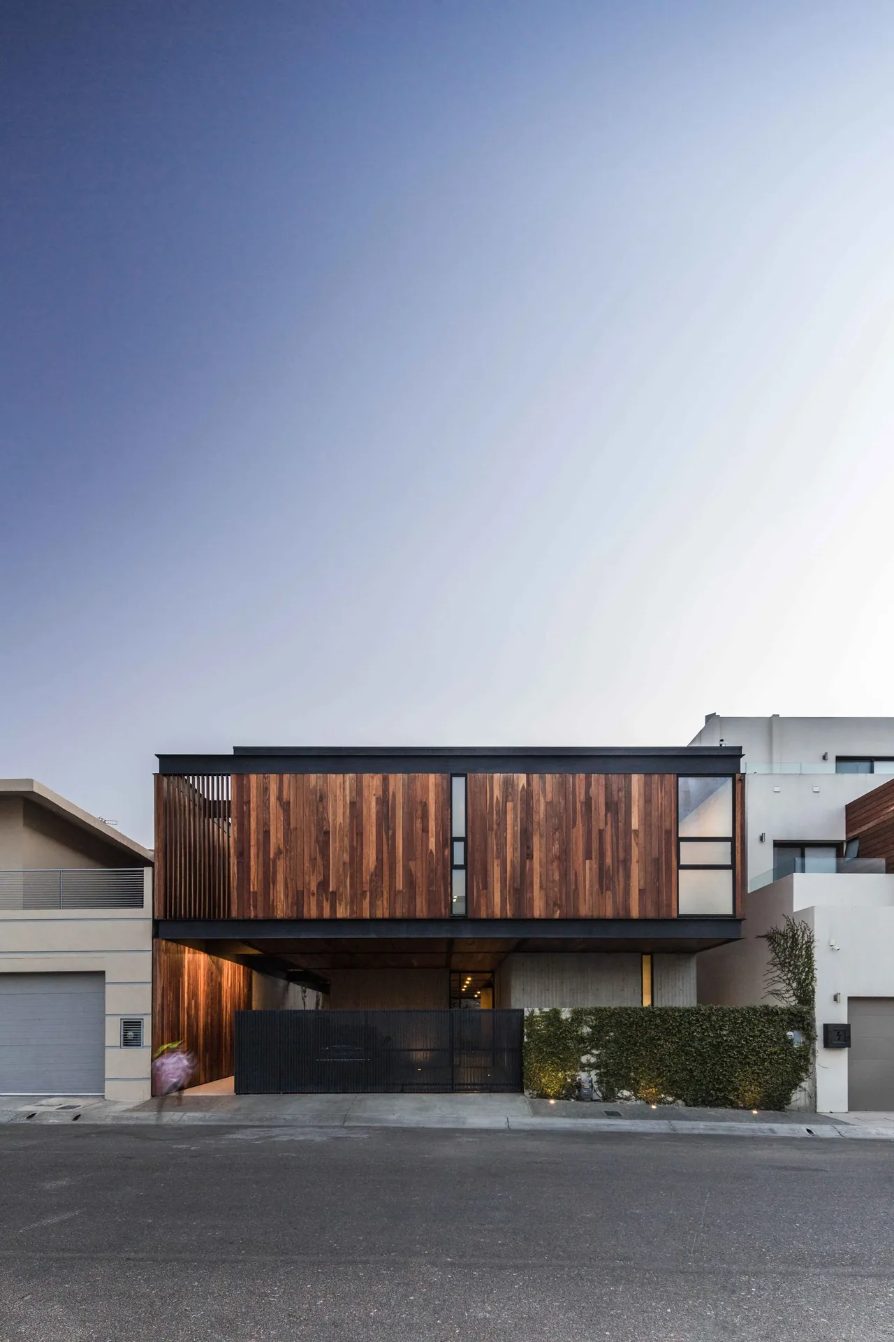 Gracia Studio's modern home features wood slat cladding and a black metal gate in San Diego.