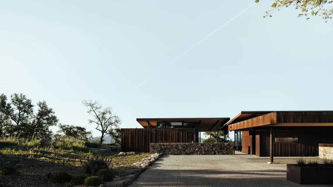 HOUSE FOR A NEW BEGINNING by Nielsen Schuh Architects features flat roofs, dark wood siding, and stone walls in San Francisco.