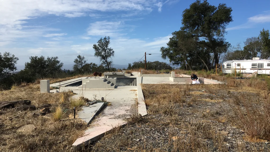 Site with concrete foundation work underway for a project called HOUSE FOR A NEW BEGINNING.