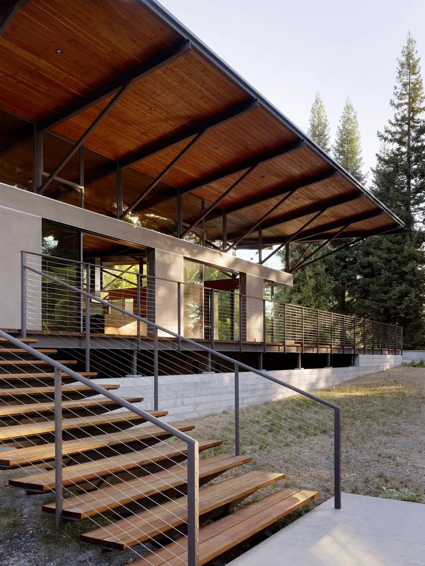 Sonoma Mountain House features an overhanging wooden ceiling roof and metal railing on the raised concrete foundation deck.