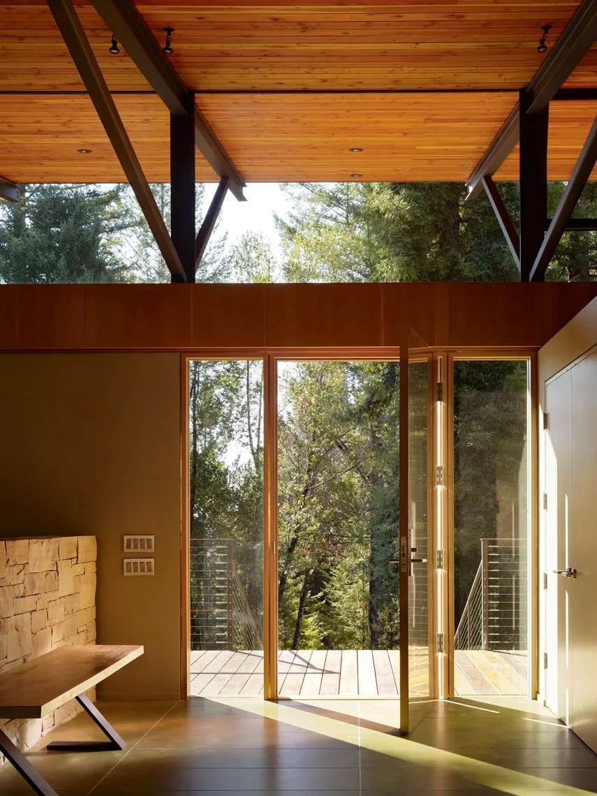Interior with glass door opens onto deck featuring metal railing at Sonoma Mountain House.