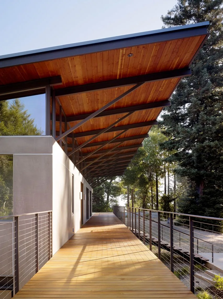 Exterior side view of Sonoma Mountain House deck showing wood ceiling soffit and metal cable railings.