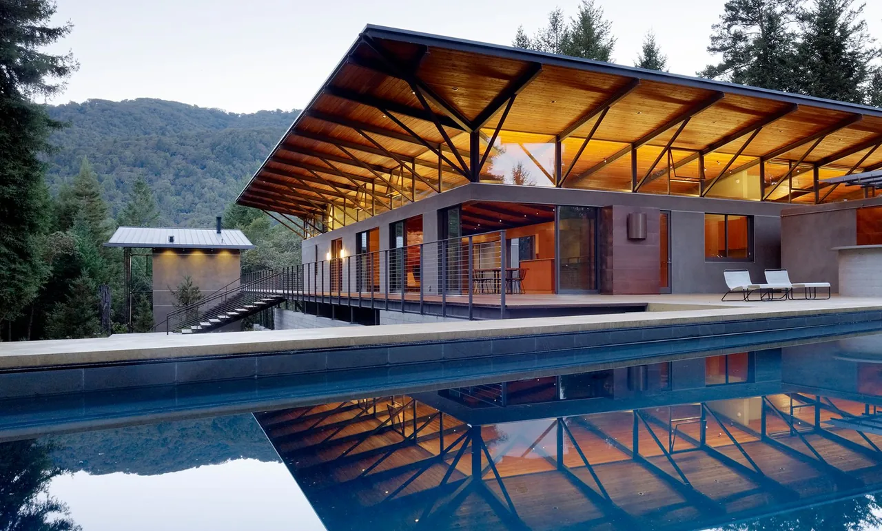Sonoma Mountain House by Nielsen Schuh Architects features a raised structure with a large overhanging wood plank ceiling roof and metal bracing.