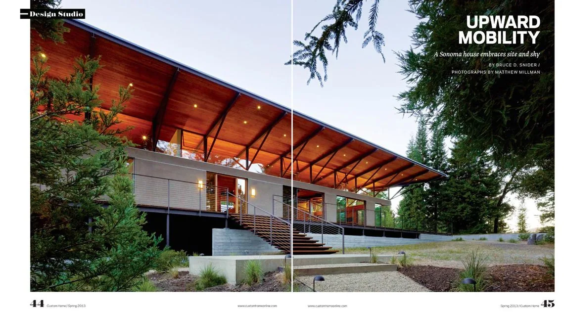 Sonoma Mountain House features an expansive wood plank ceiling roof with metal bracing over a raised concrete foundation in a forest setting.