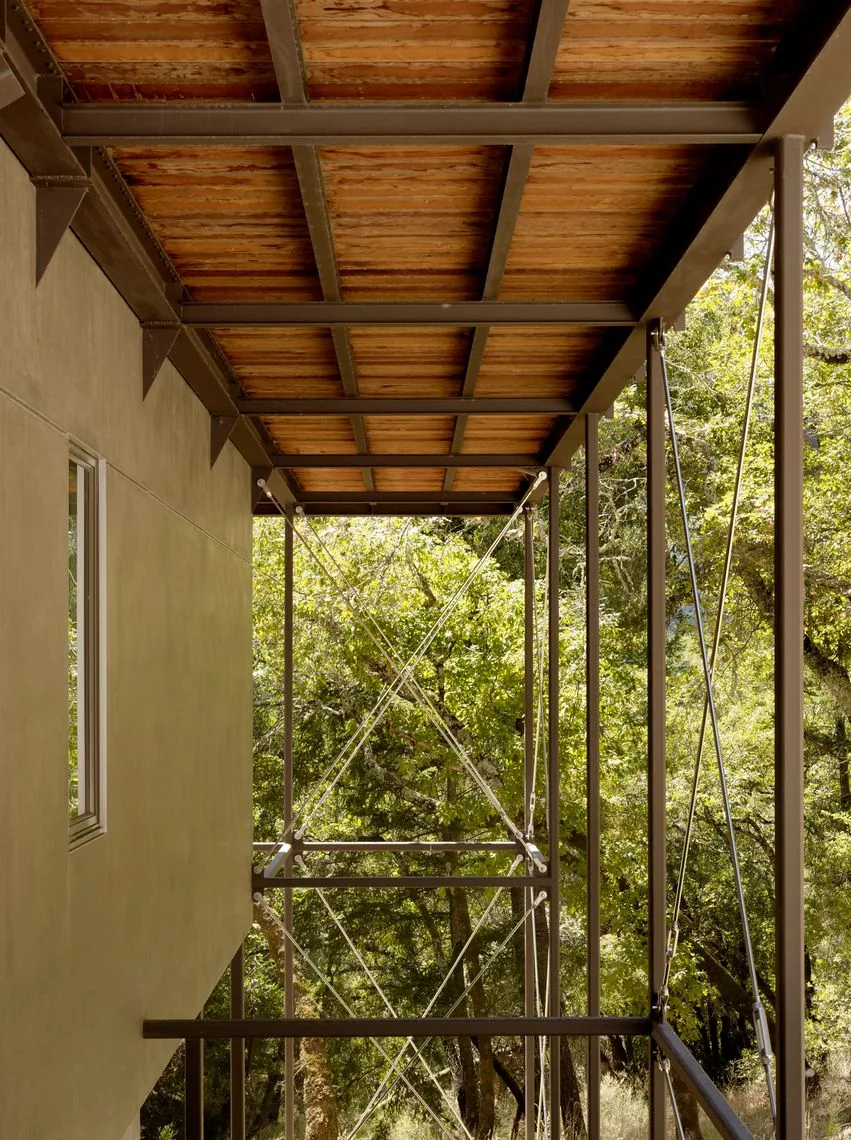 Covered outdoor balcony with wood ceiling soffit and metal structural framing.