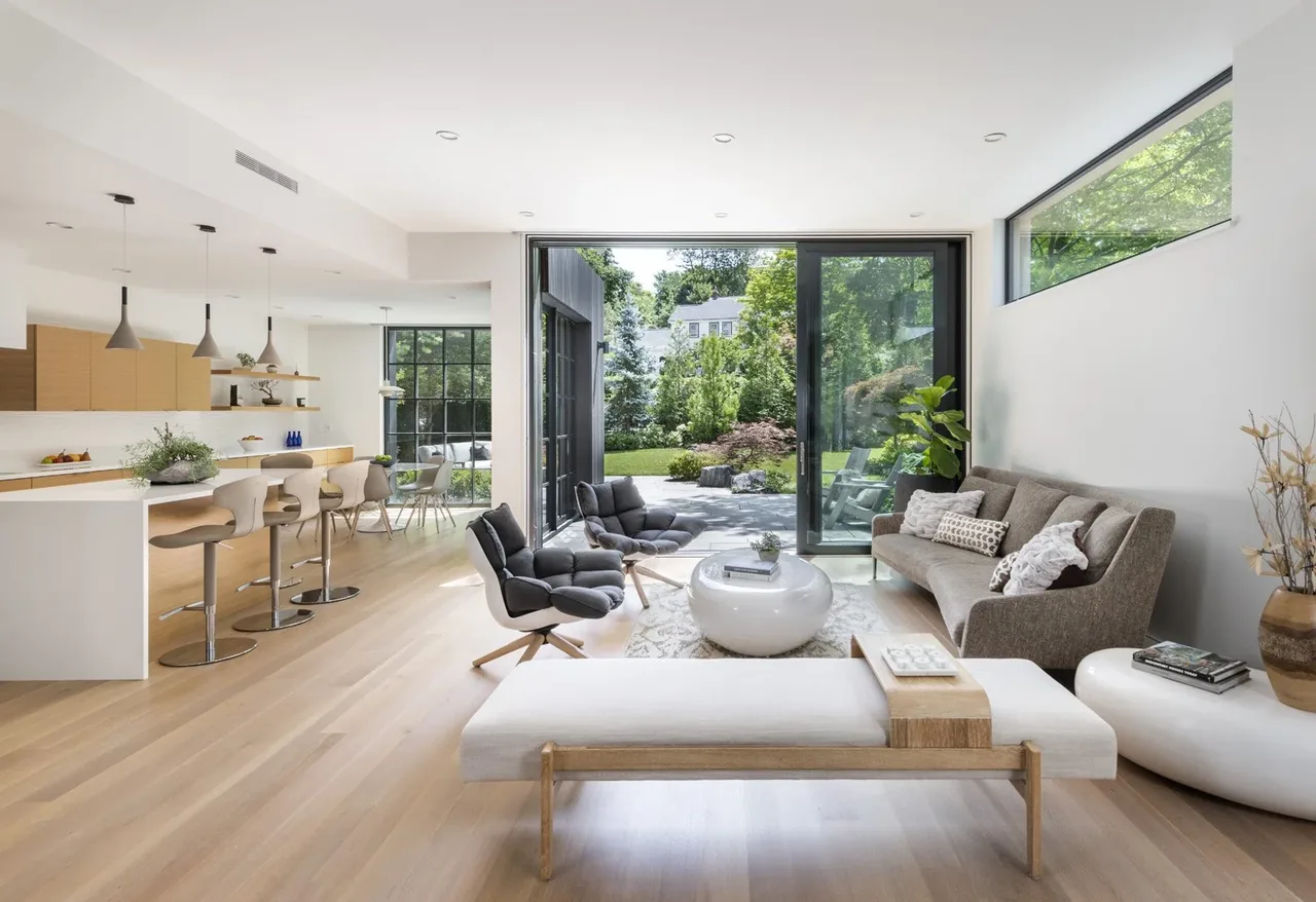 Belmont Modern features an open living and kitchen area with large sliding glass doors leading to the backyard patio.