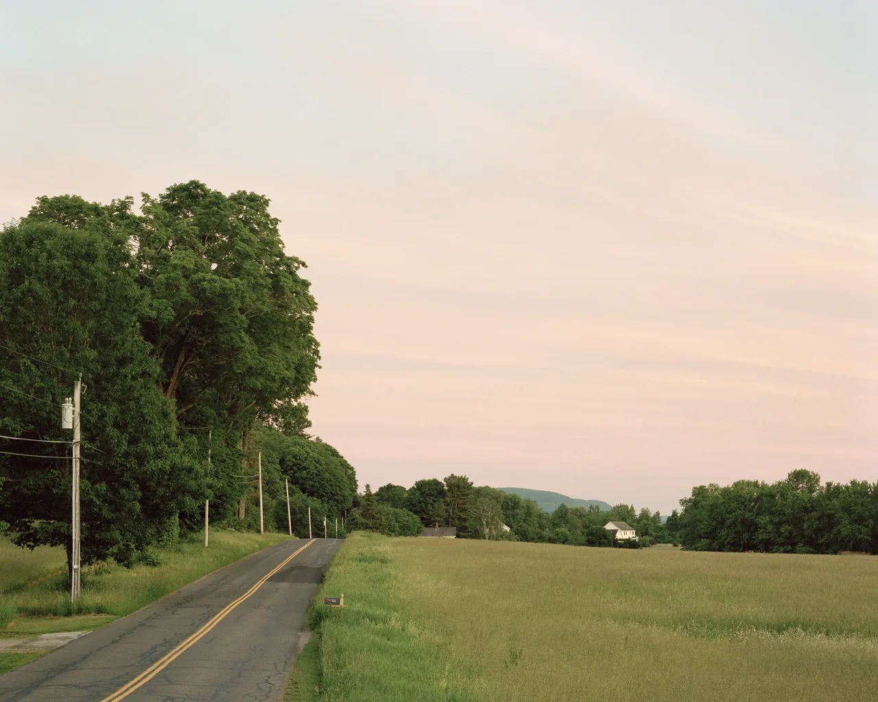 Approach view of the Berkshire Residence showing the surrounding rural landscape and road access.