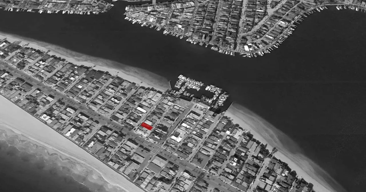 Aerial view of a coastal urban neighborhood with the project building highlighted in red.