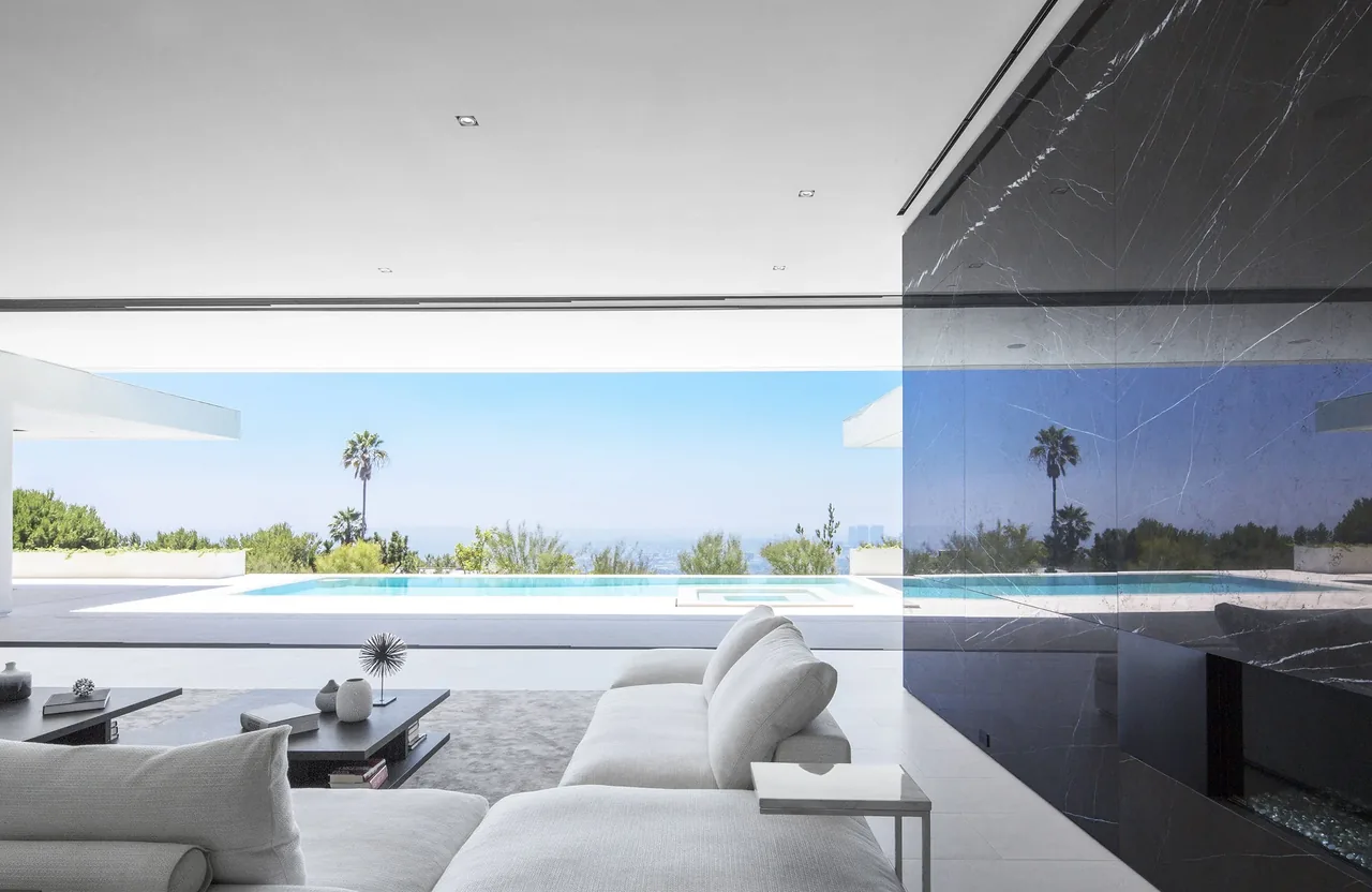 Living room with open wall to infinity pool and city view in the Mirrorhouse project.