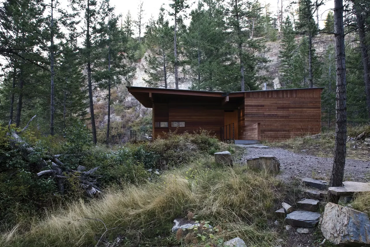 Cabin on Flathead Lake by Andersson Wise Architects features a wooden exterior and a shed roof, set in a natural forested landscape.