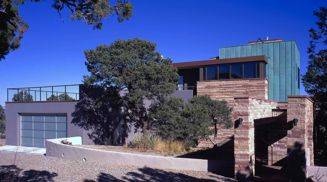 The Greene project features a modern multi-level house combining stone, metal, and glass materials with a flat roof.