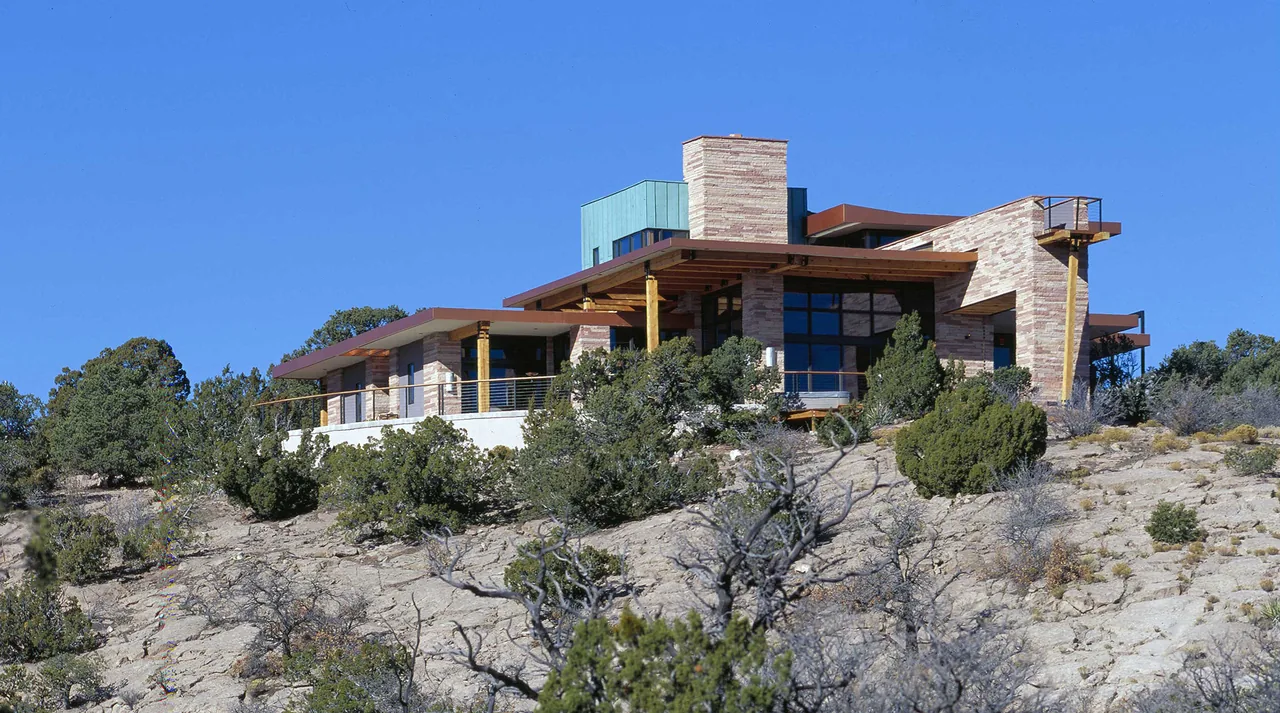 The Greene project features a modern hillside home with extensive natural stone cladding and large glazed openings.